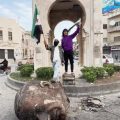 Syrians Pose Next to Head of Toppled Statue of Hafez al-Assad in Hama